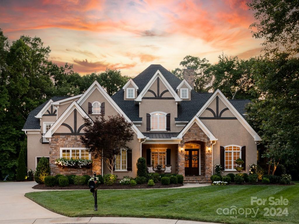 a front view of a house with a garden and trees