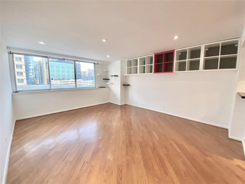 a view of empty room with wooden floor and windows