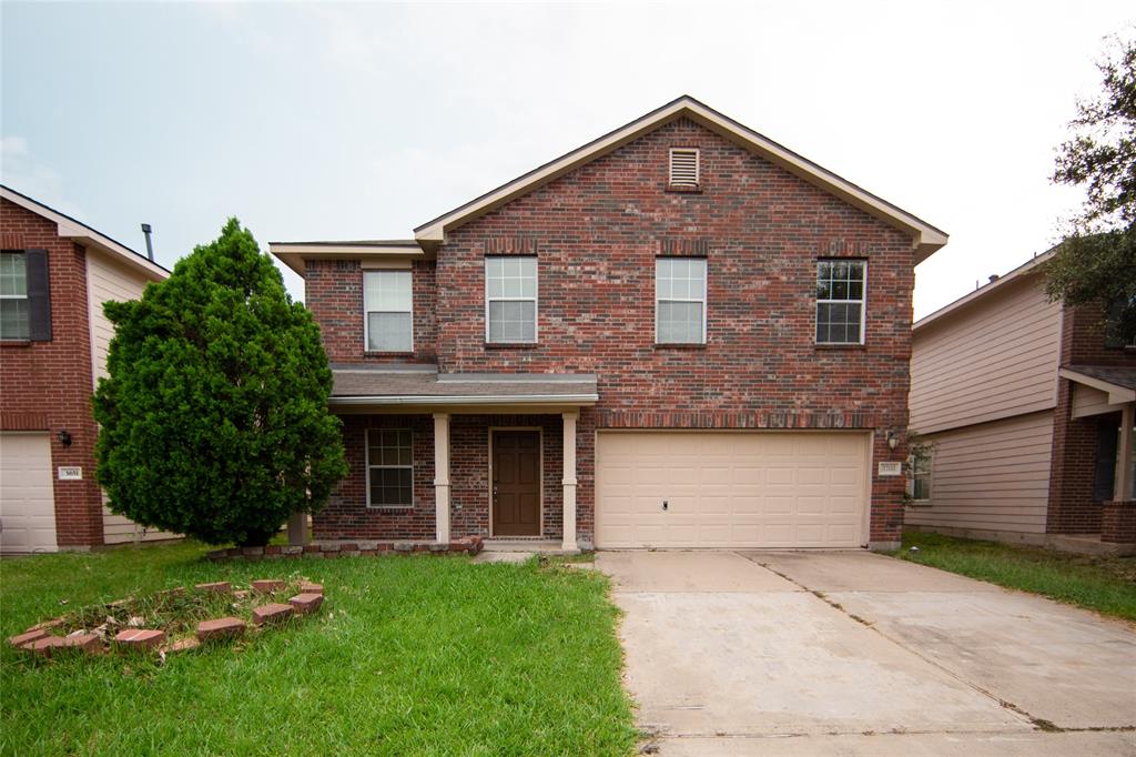 a front view of a house with a garden and yard