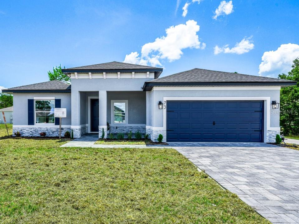 a front view of a house with a yard and garage