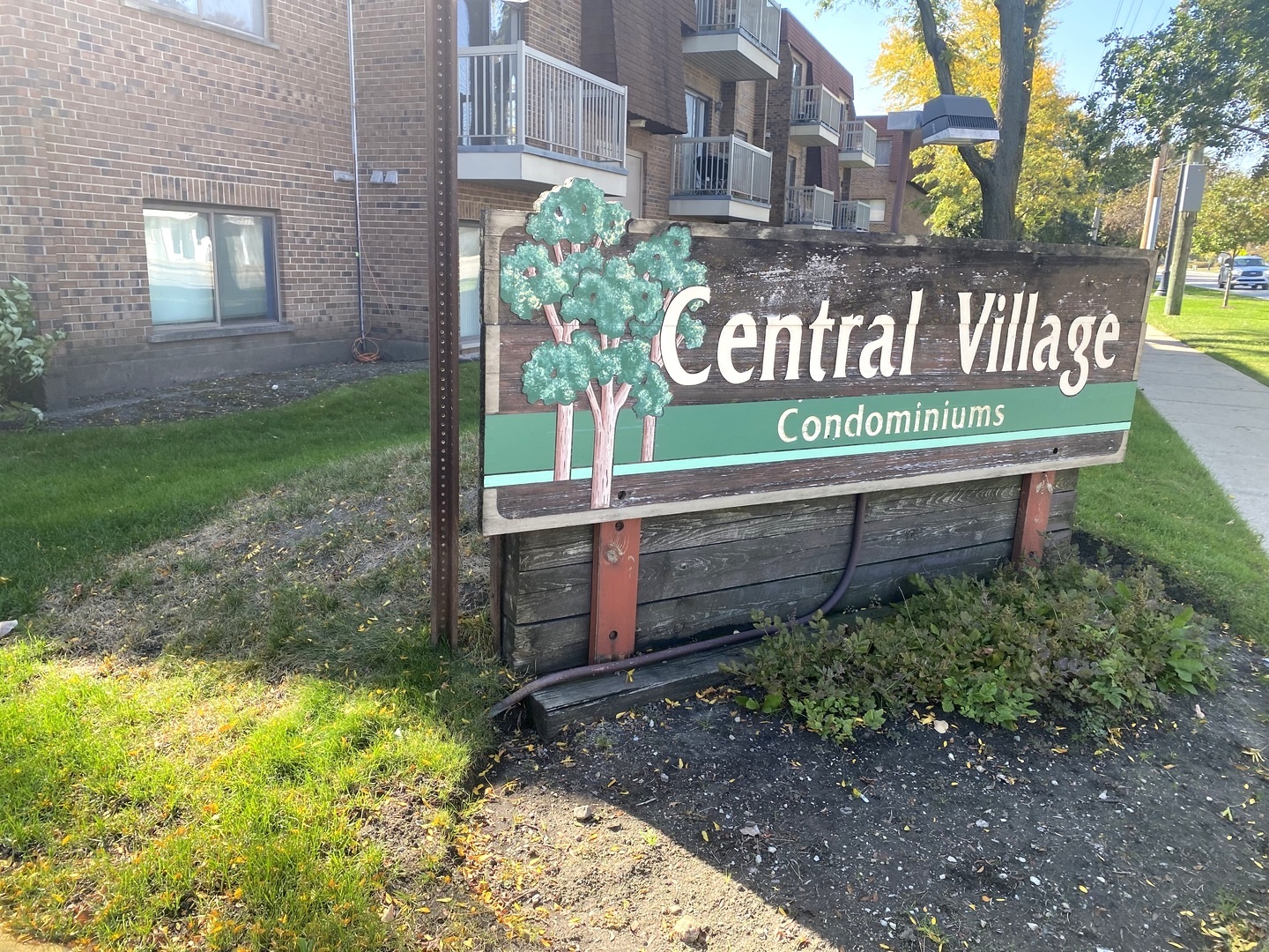 a sign that is sitting in front of a brick house