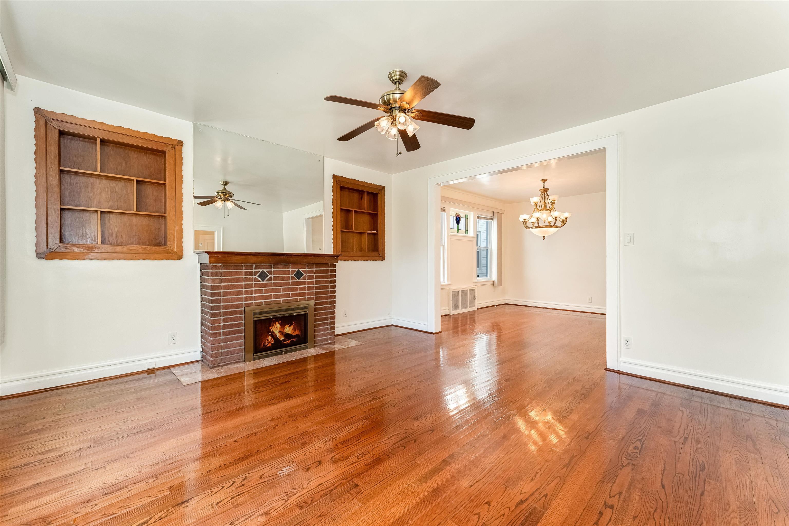 a view of empty room with fireplace and wooden floor