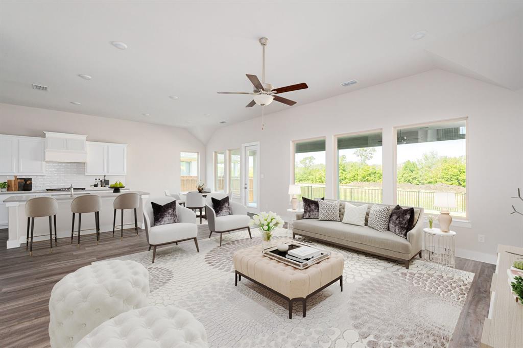 a living room with furniture a table and a large window