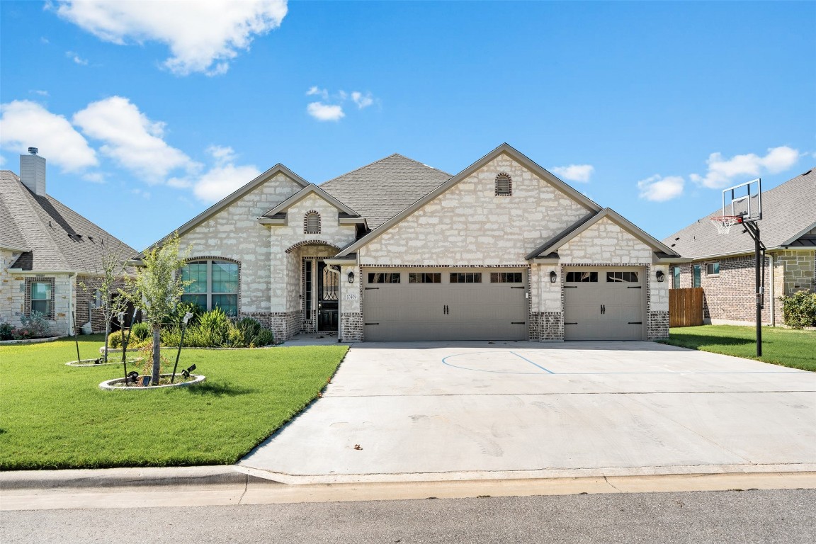 a front view of a house with a yard and garage