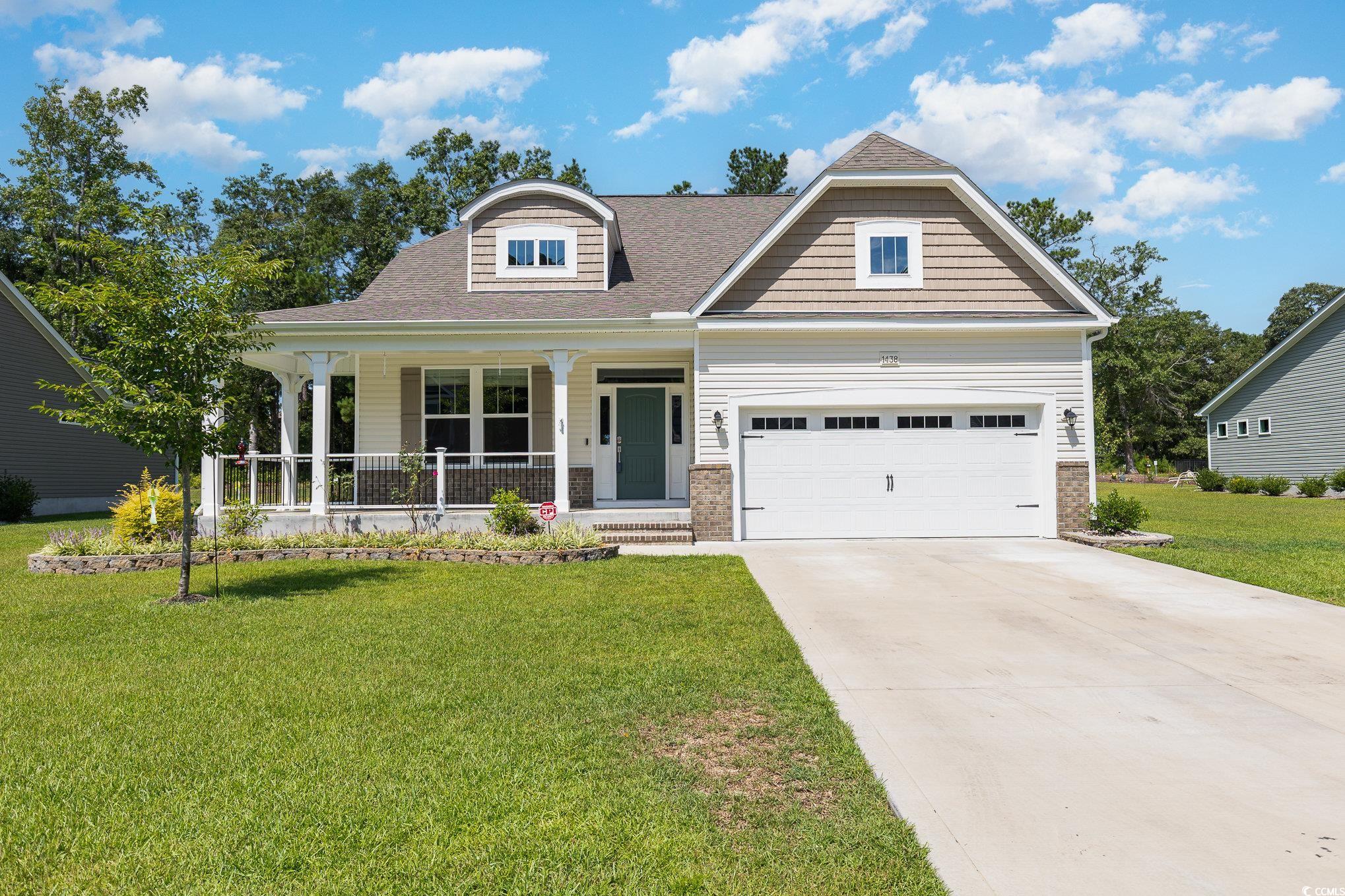 View of front of home with a garage, a front lawn,