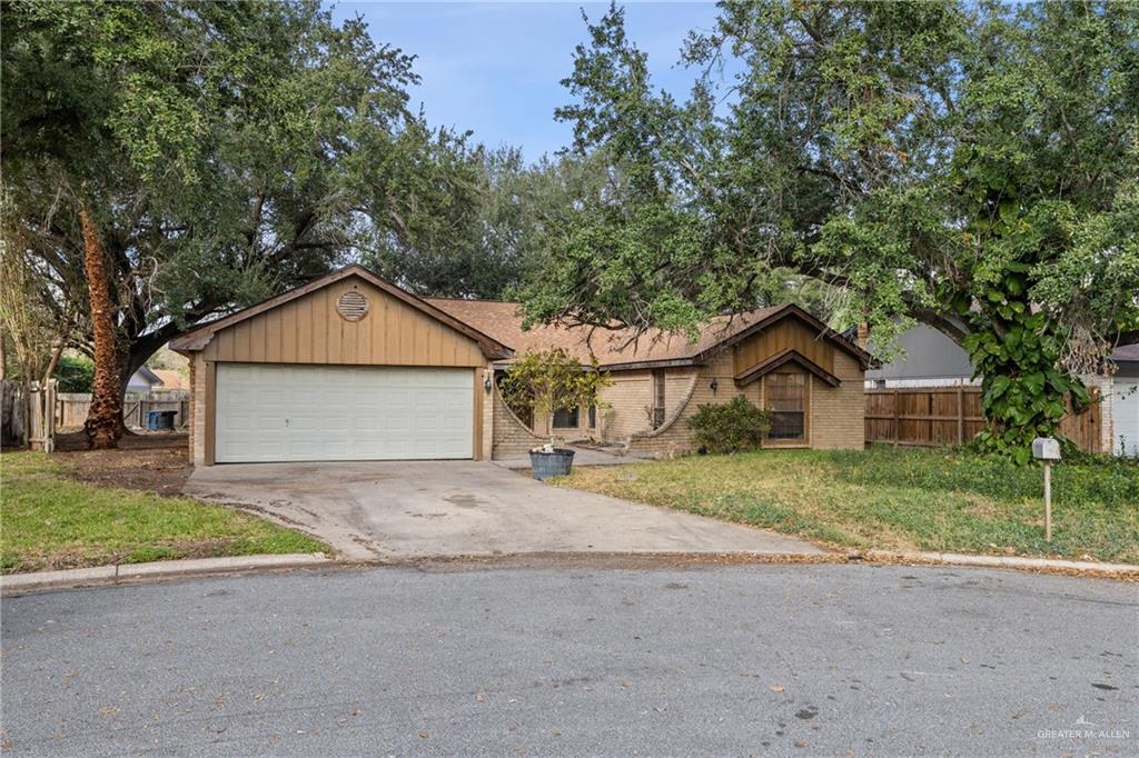 a view of a house with a yard and large tree