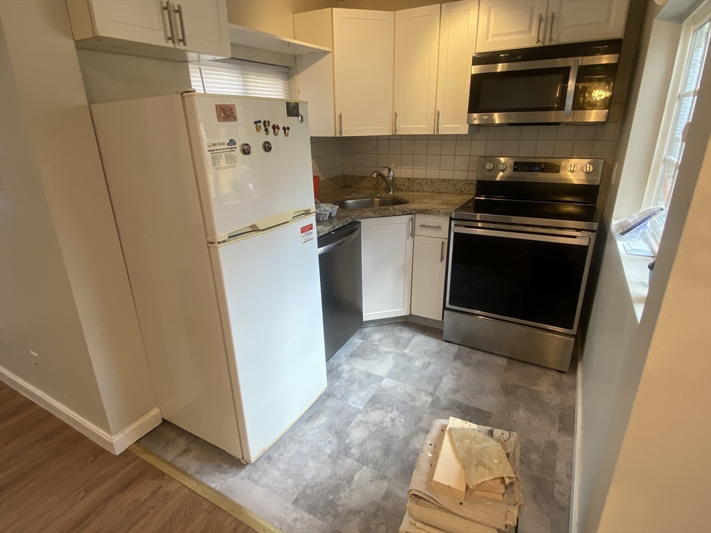 a kitchen with a refrigerator stove and microwave