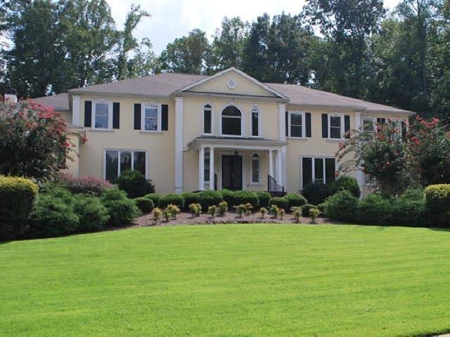 a front view of a house with a yard and trees