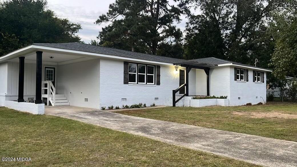 a view of a house with backyard and trees