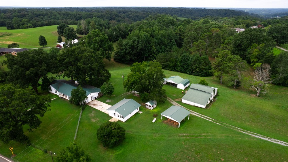 an aerial view of residential house with outdoor space and trees all around