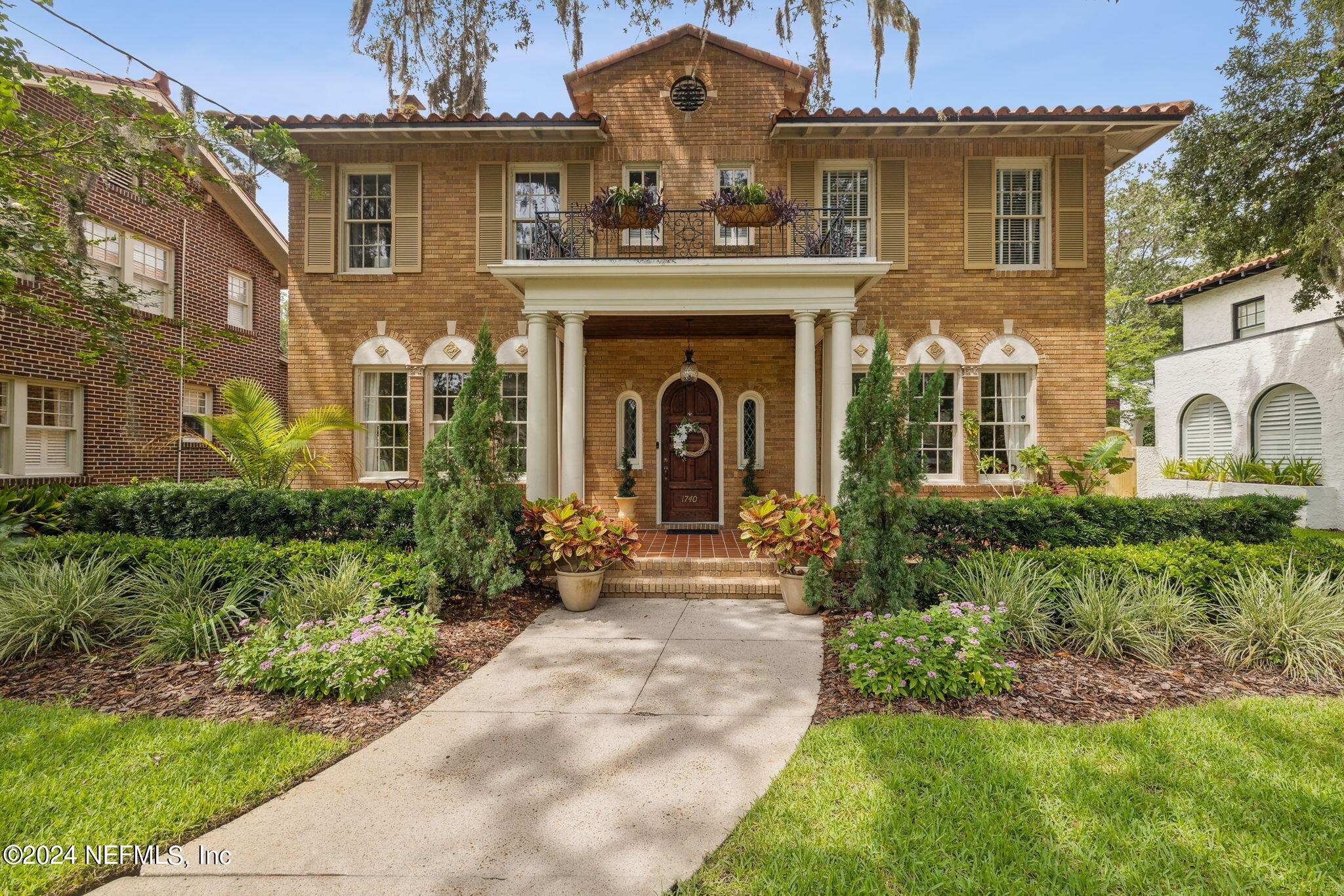 a front view of a house with yard and green space