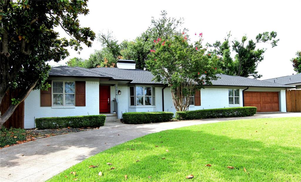 a front view of a house with a garden and yard