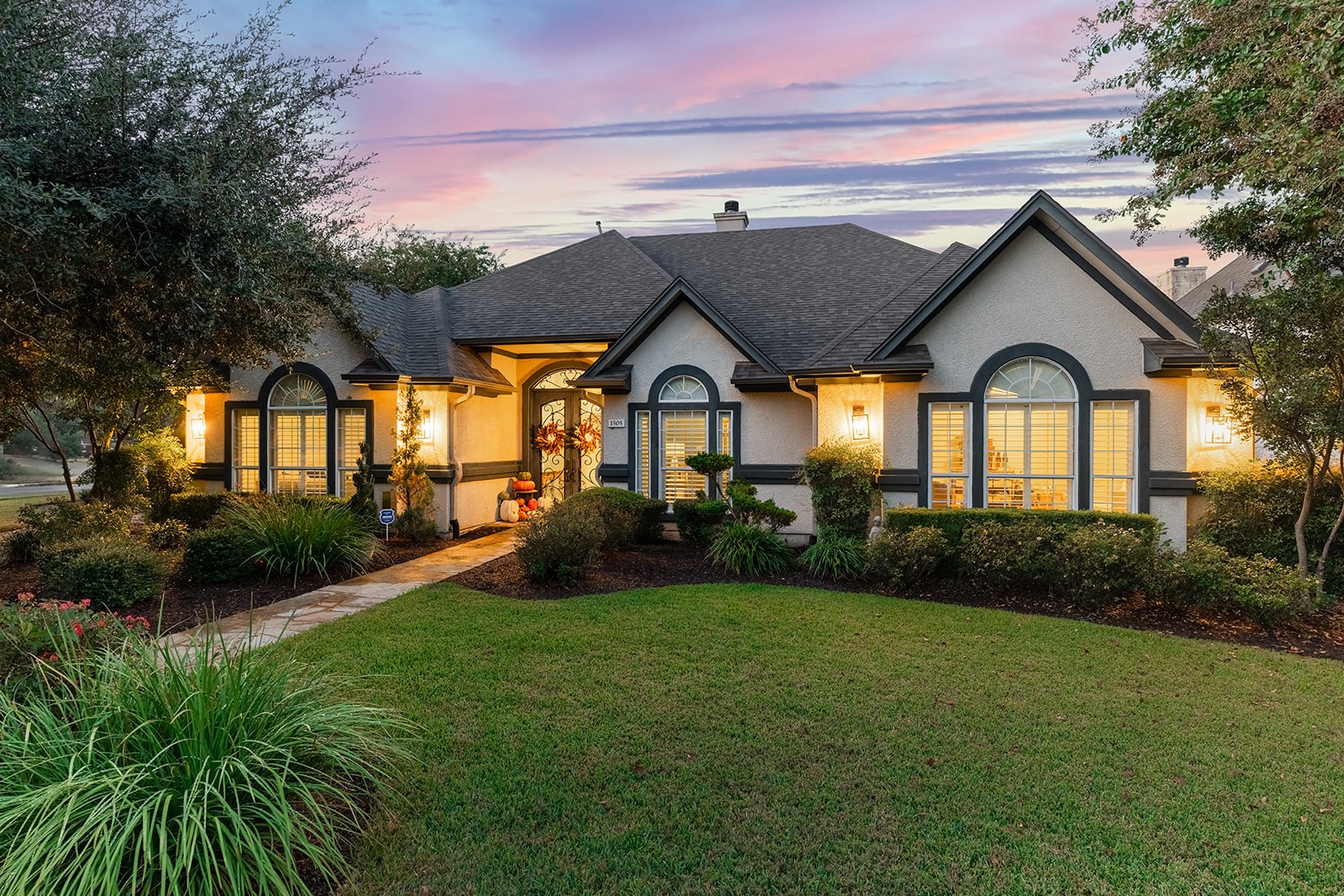 a view of a big house with a big yard and potted plants