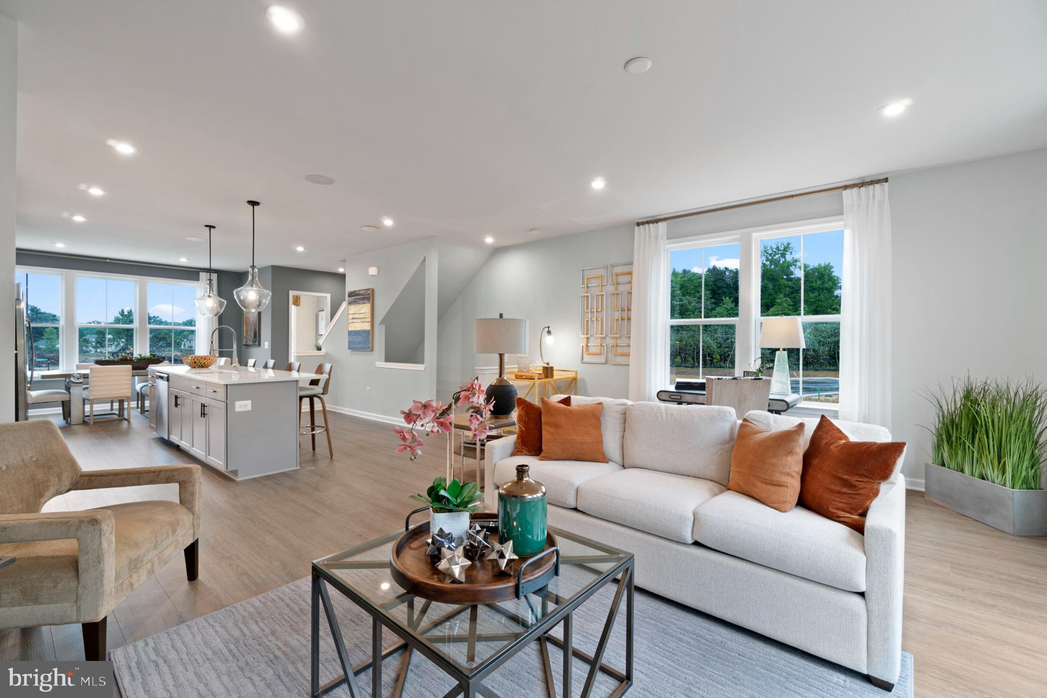 a living room with furniture kitchen and a large window