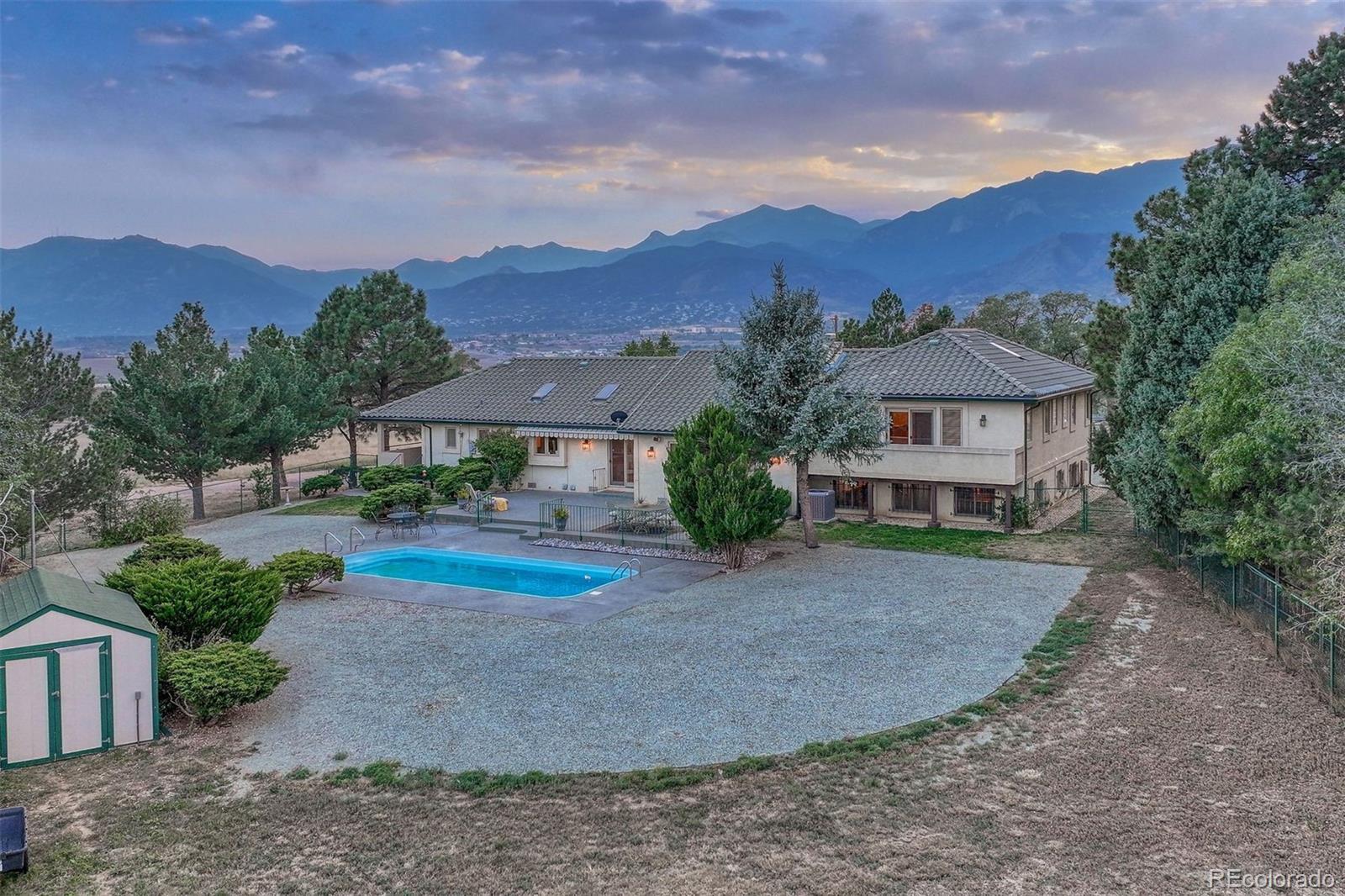 a front view of a house with a yard and mountain view