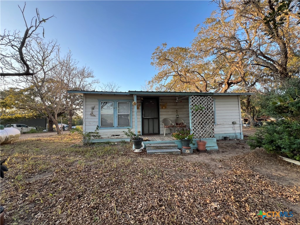 a view of a house with a yard and large tree