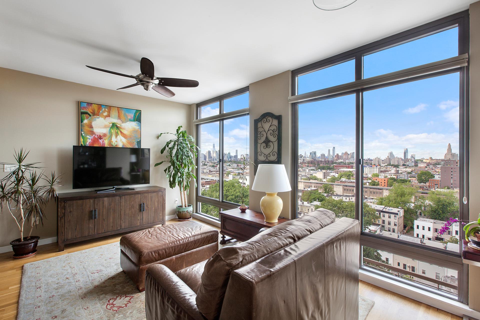 a living room with furniture a flat screen tv and a large window