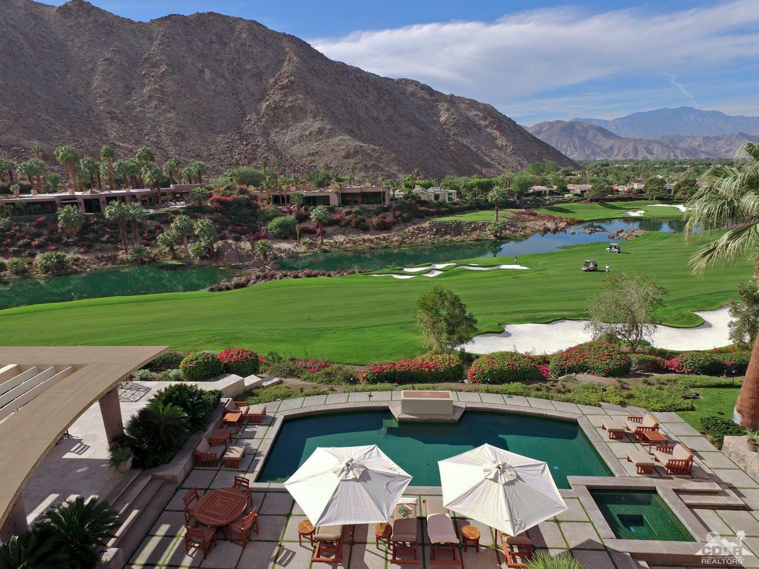 an aerial view of a house with a garden and lake view