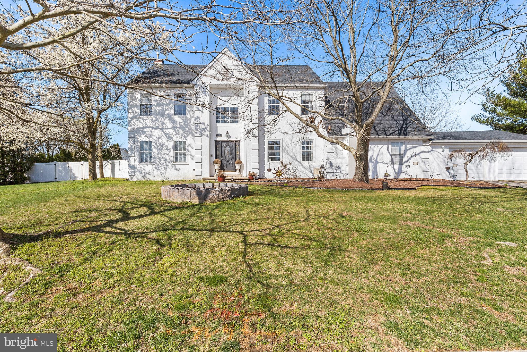 a view of a white house with a yard and sitting area