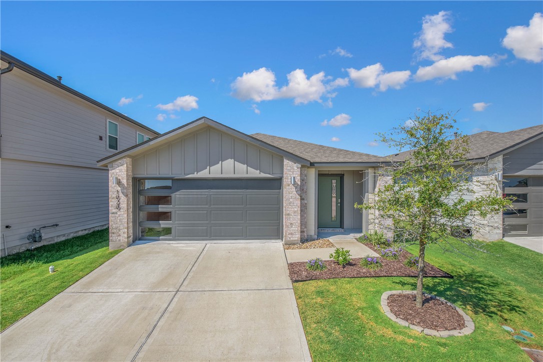 View of front of home with a garage and a front la