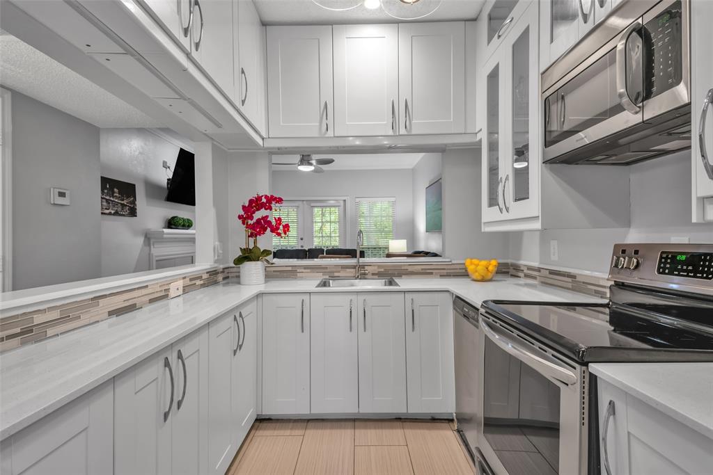 a kitchen with stainless steel appliances granite countertop a sink stove and cabinets