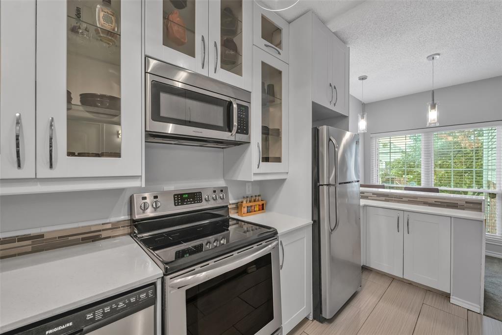 a kitchen with stainless steel appliances a stove microwave and sink