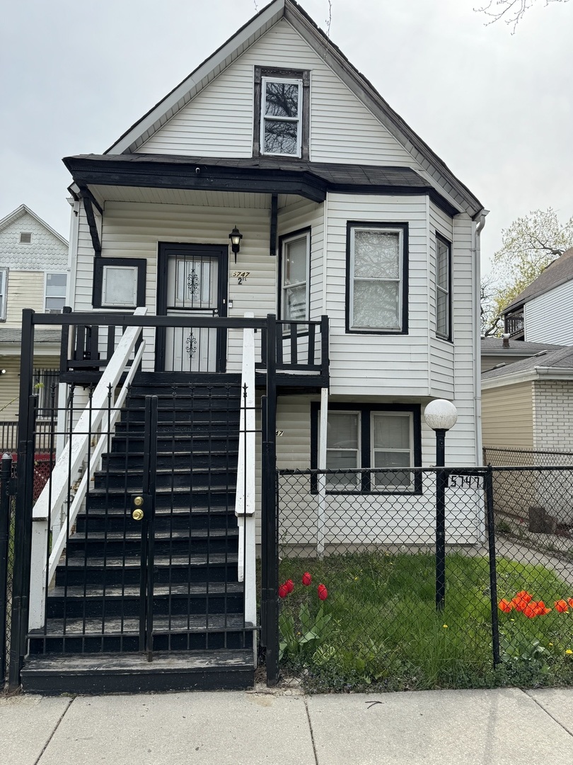 a view of a house with wooden fence and a street