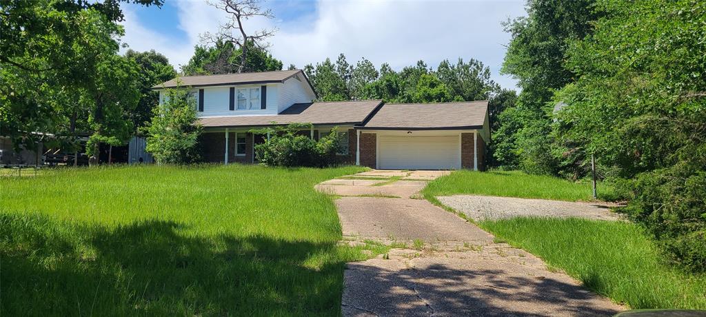 a view of a house with a big yard potted plants and large tree