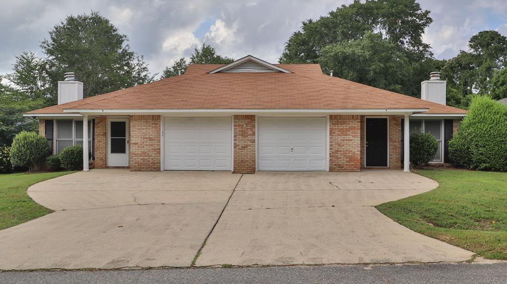 a front view of a house with a yard and trees