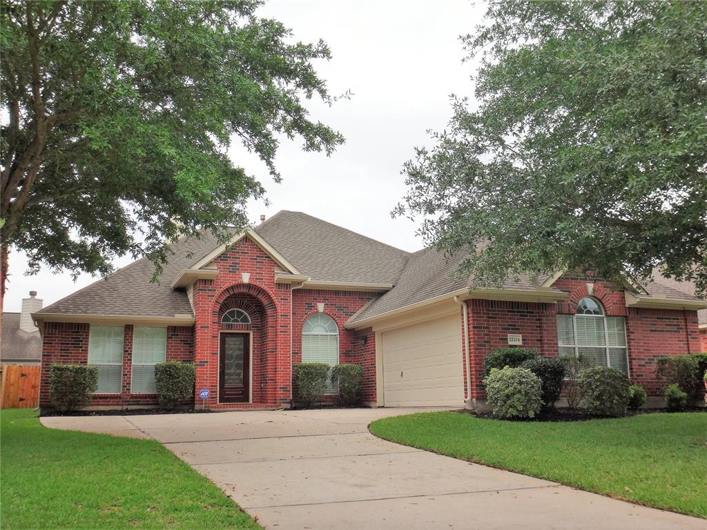 a front view of a house with a garden and trees