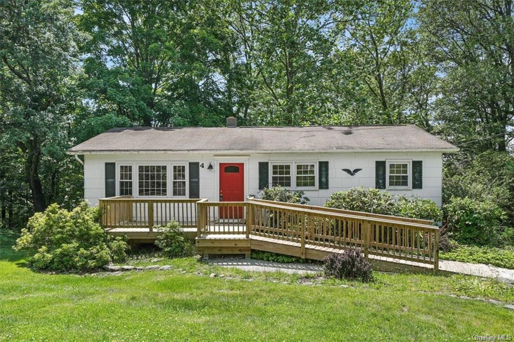 Ranch-style home with a deck and a front yard