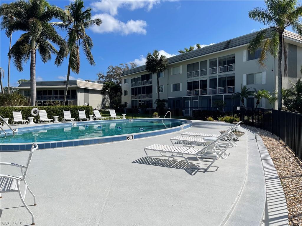 a view of a white house with a yard and palm trees