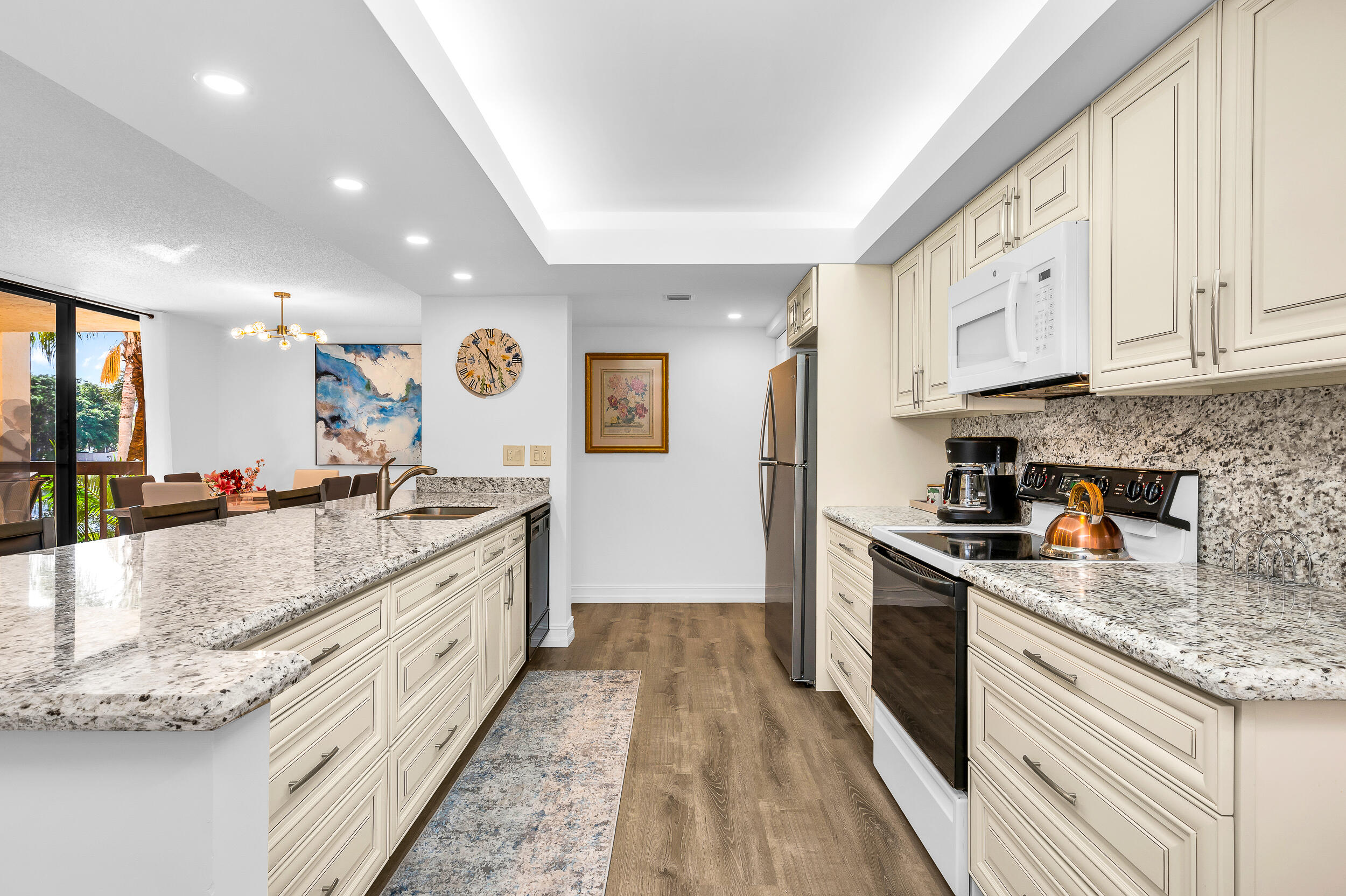 a large kitchen with stainless steel appliances granite countertop a lot of counter space and wooden floors