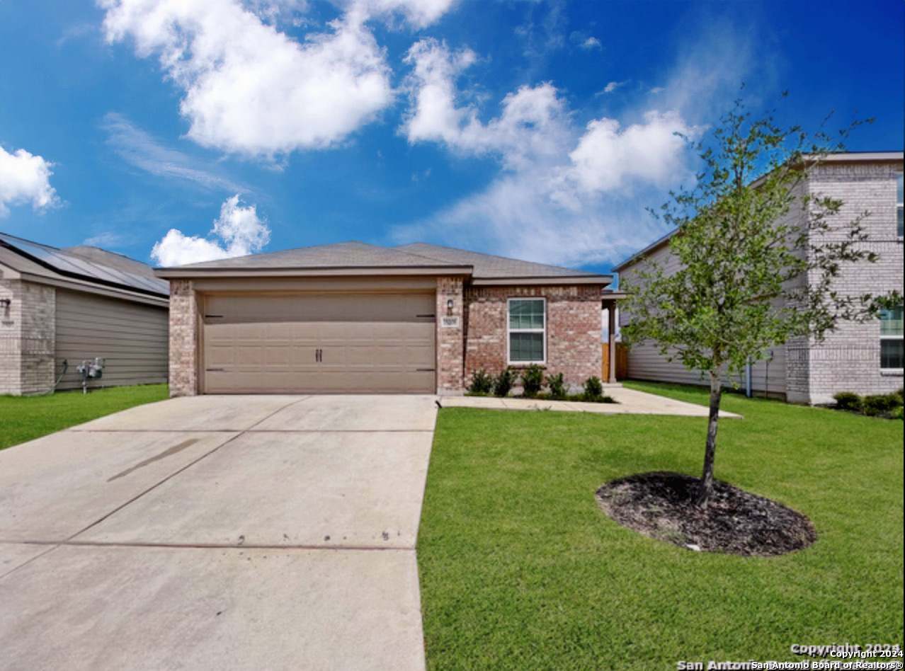 a front view of a house with a yard and garage