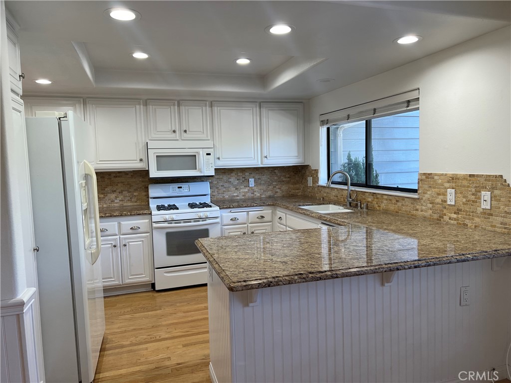 a kitchen with granite countertop a sink stainless steel appliances and cabinets