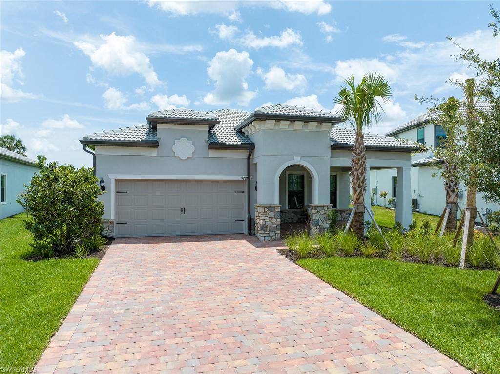 Mediterranean / spanish-style home with a garage and a front lawn