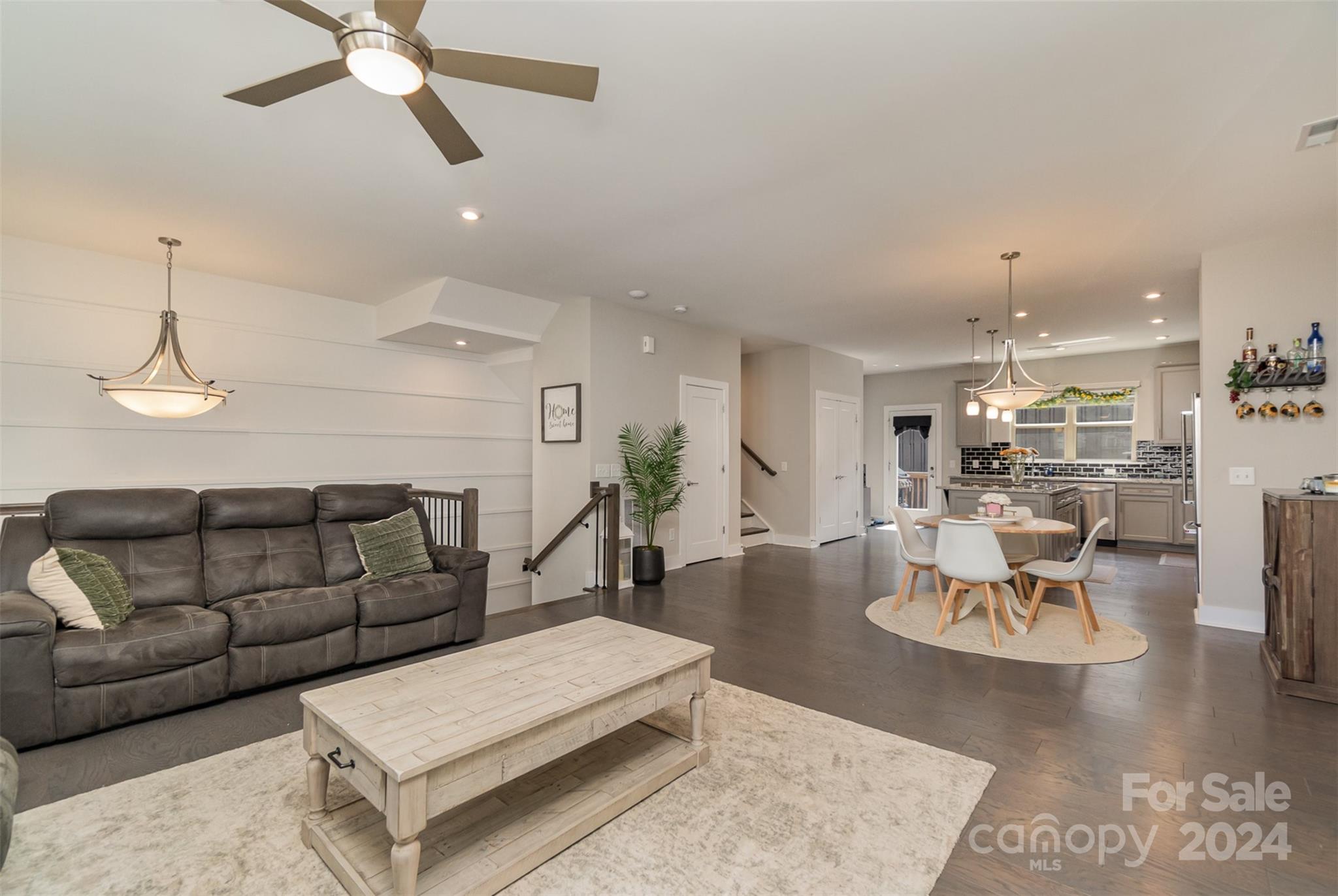 a living room with furniture and view of kitchen