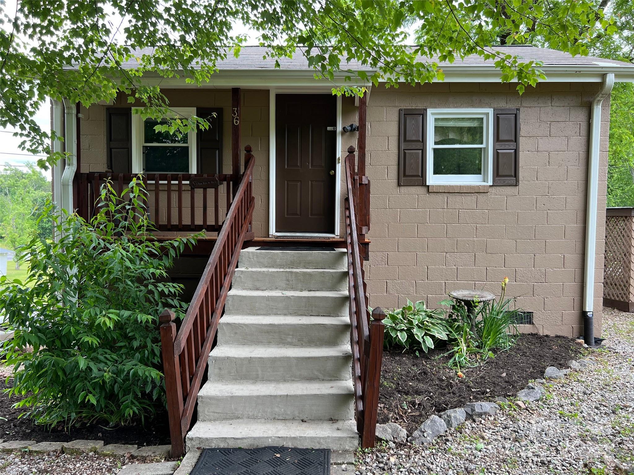 a front view of a house with plants