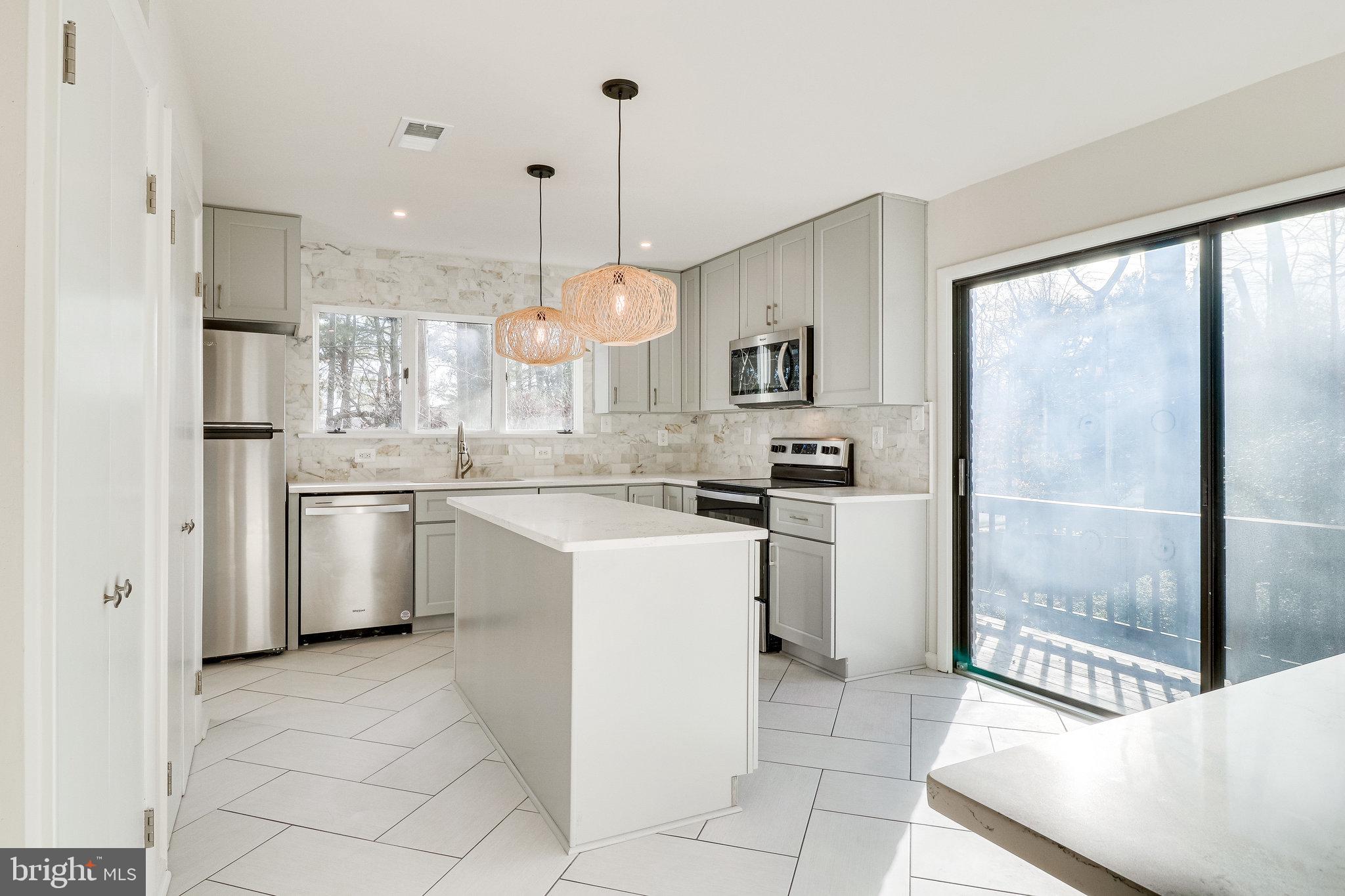 a kitchen with a sink a refrigerator and cabinets