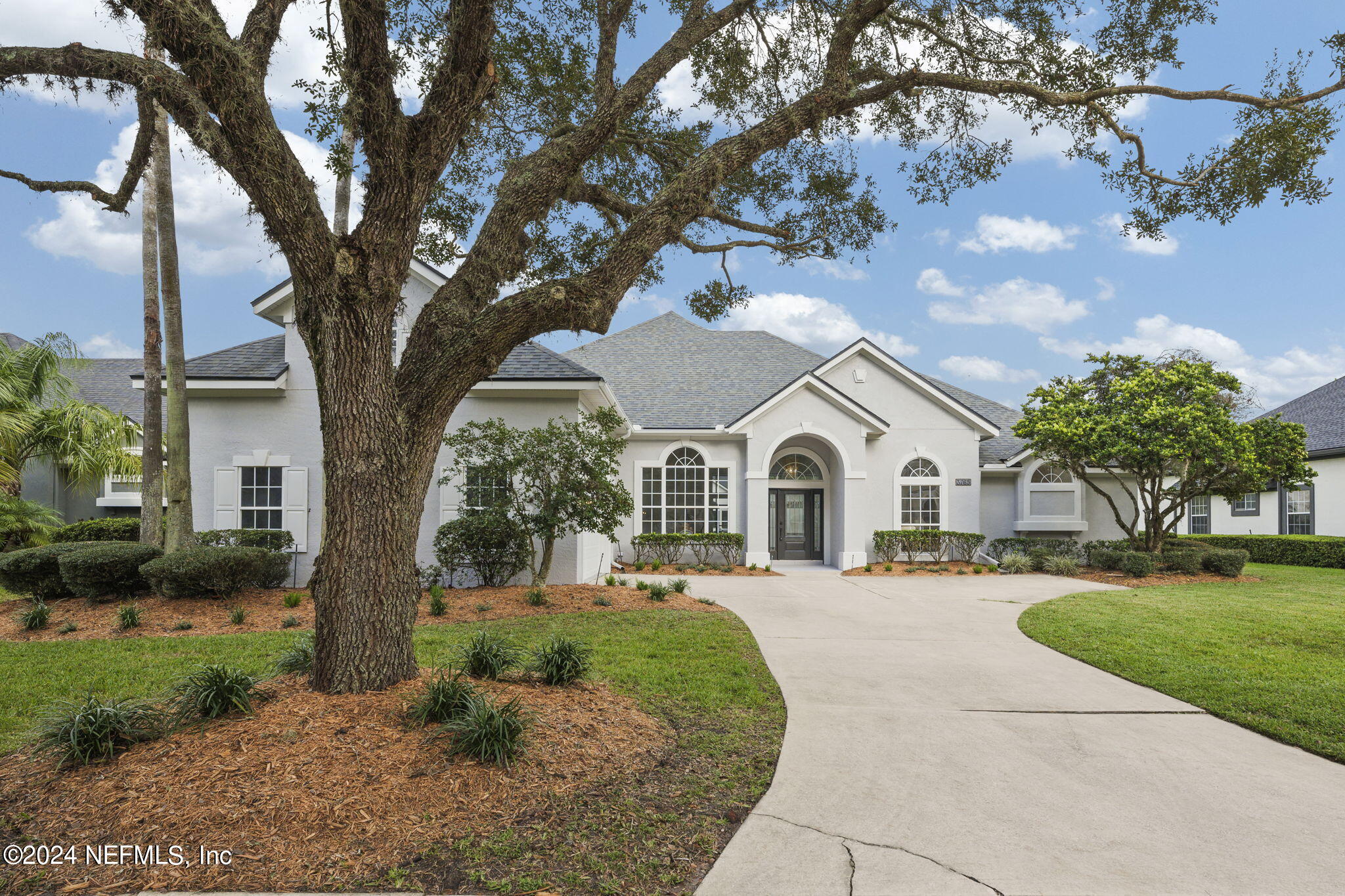 a front view of a house with a yard and trees