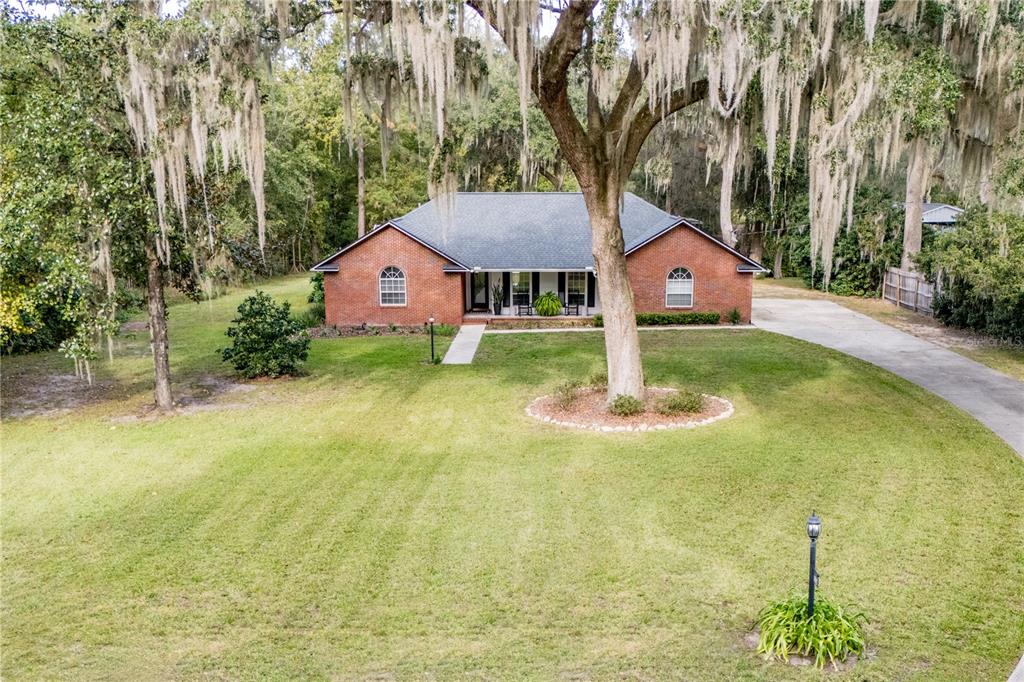 a front view of a house with a yard and trees