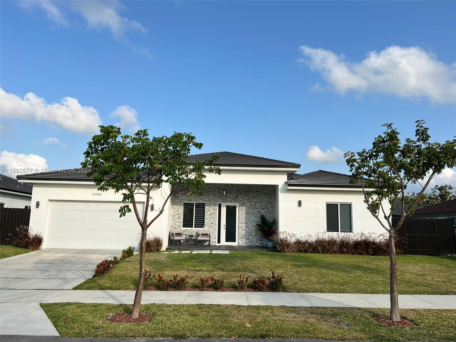 a front view of a house with a garden