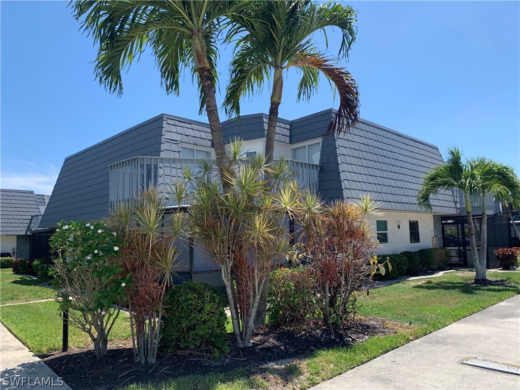 a view of a palm trees front of house with a yard