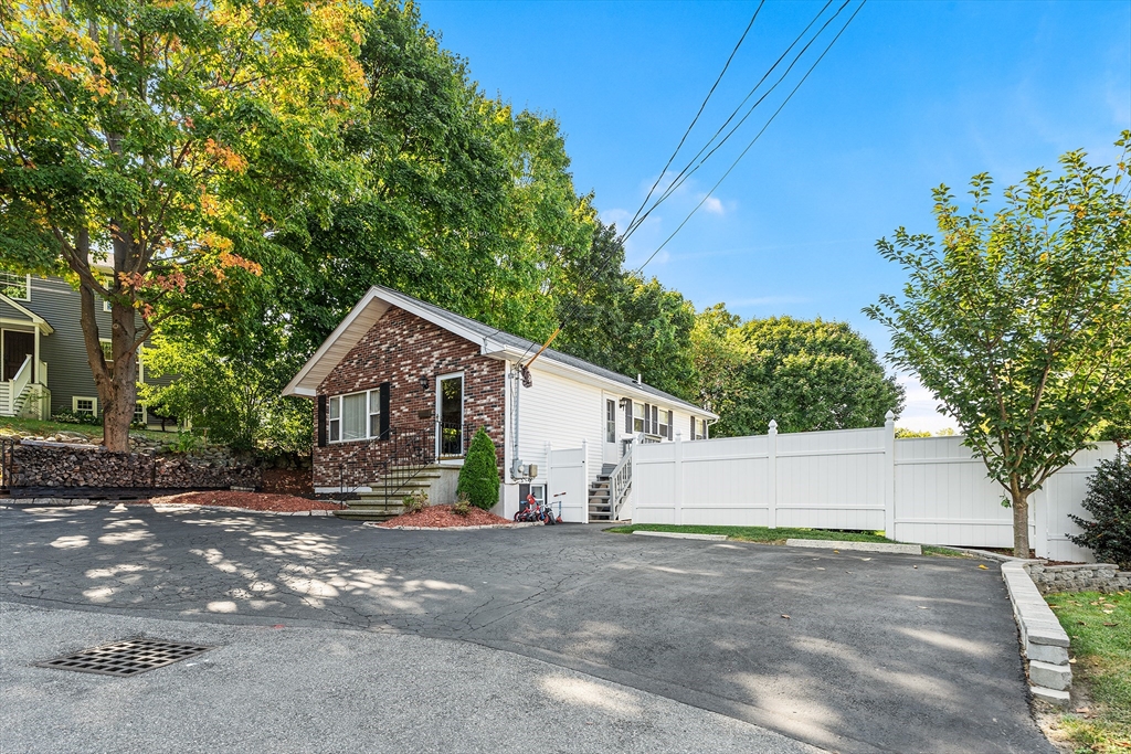 a view of a house with a yard and tree