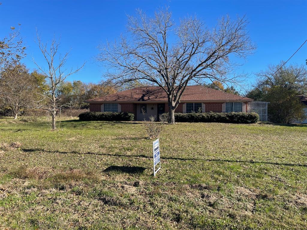 a view of house with yard in front of it