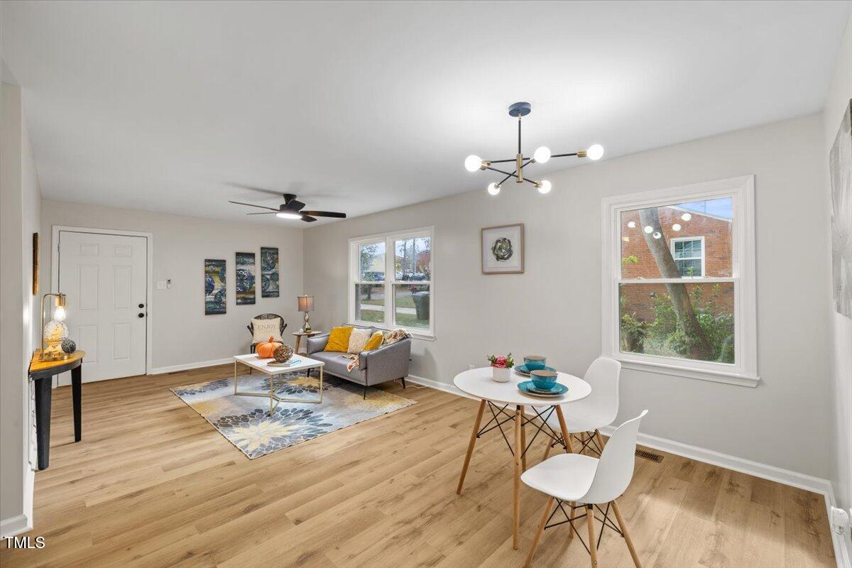 a living room with dining table furniture and a chandelier