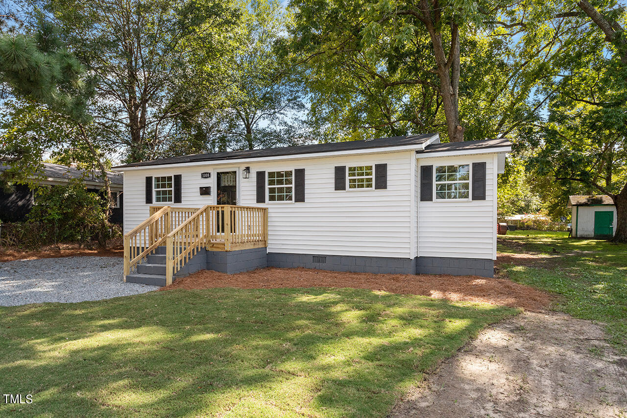 a front view of house with yard and trees in the background