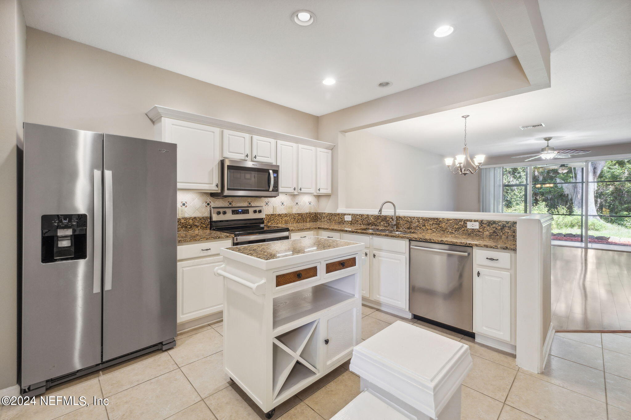 a kitchen with stainless steel appliances granite countertop a stove a refrigerator and a sink