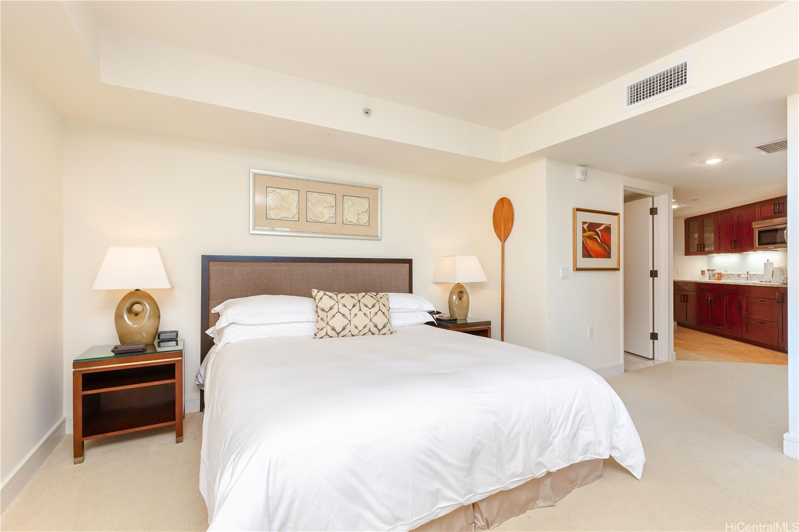 a bedroom with a bed and a view of kitchen