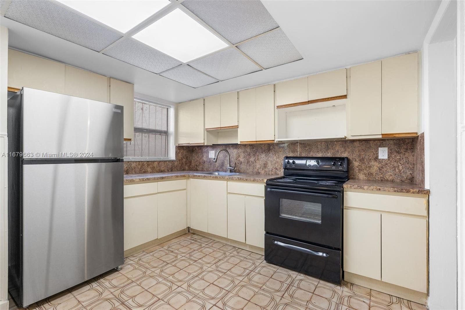 a kitchen with a refrigerator sink and cabinets